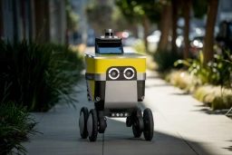 A yellow, four-wheeled, autonomous delivery robot by Serve Robotics.